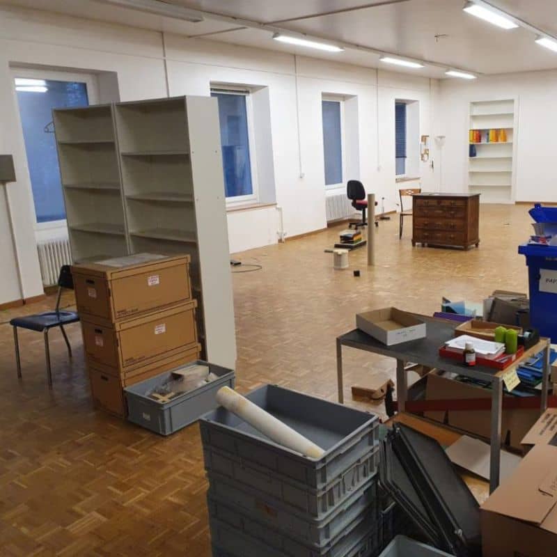 Bureau professionnel en cours de débarras avec rayonnages et caisses
