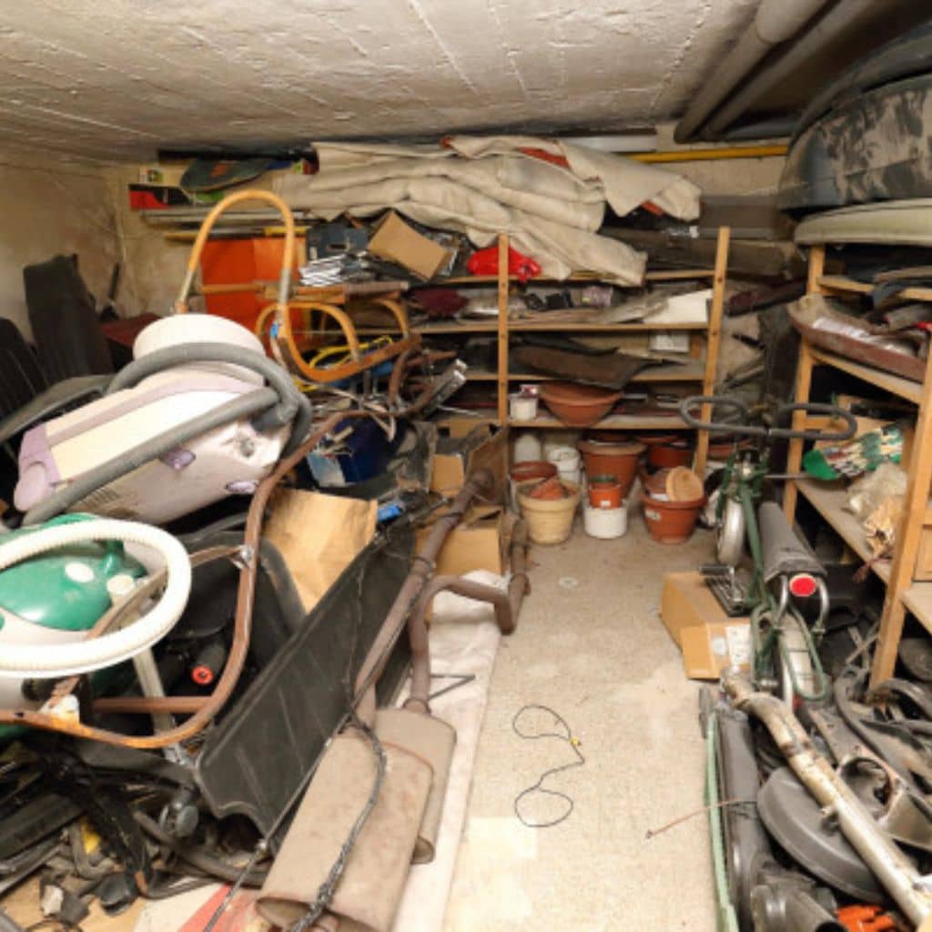 Garage encombré d’outils, de vélos et de cartons avant débarras